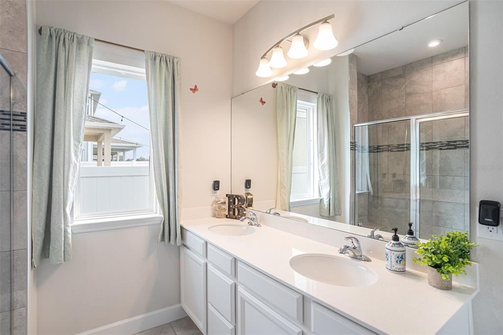 19056 Heavenside Ct Spring Hill Spring Hill, FL 34610 - Photo 14 of 25 a bathroom with a shower sink vanity and mirror