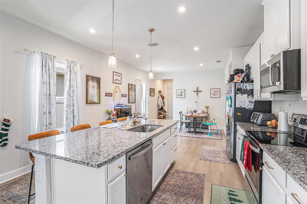 19056 Heavenside Ct Spring Hill Spring Hill, FL 34610 - Photo 9 of 25 a kitchen with stainless steel appliances granite countertop a sink stove and refrigerator