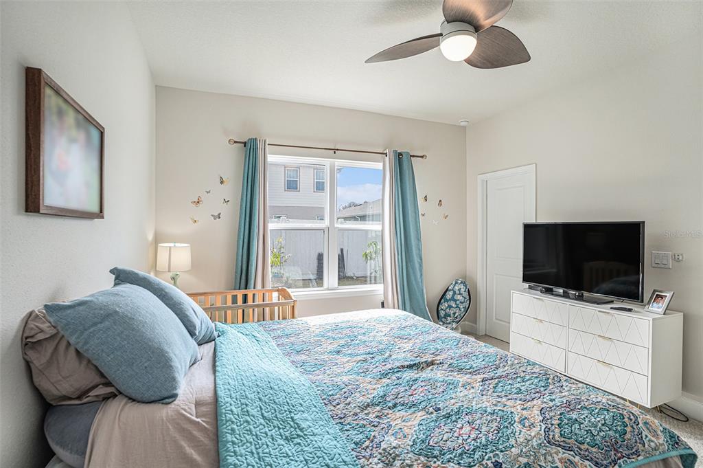 19056 Heavenside Ct Spring Hill Spring Hill, FL 34610 - Photo 10 of 25 a bedroom with a bed and a flat tv screen on dresser