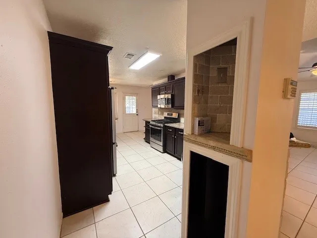 a kitchen with granite countertop a refrigerator stove and sink