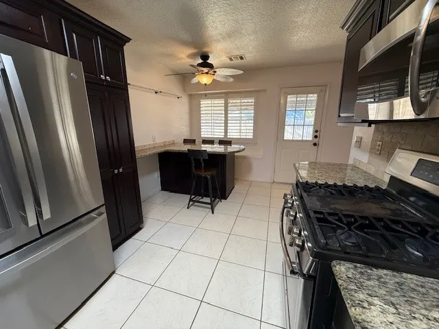 a kitchen with a table chairs and a refrigerator