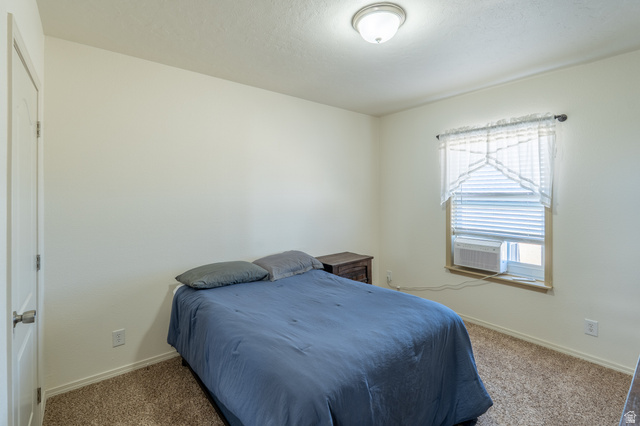 700 East Peter Springs Road Monticello, UT 84535 - Photo 27 of 57 Bedroom featuring neutral walls, a window with horizontal blinds, and a built-in ceiling light fixture
