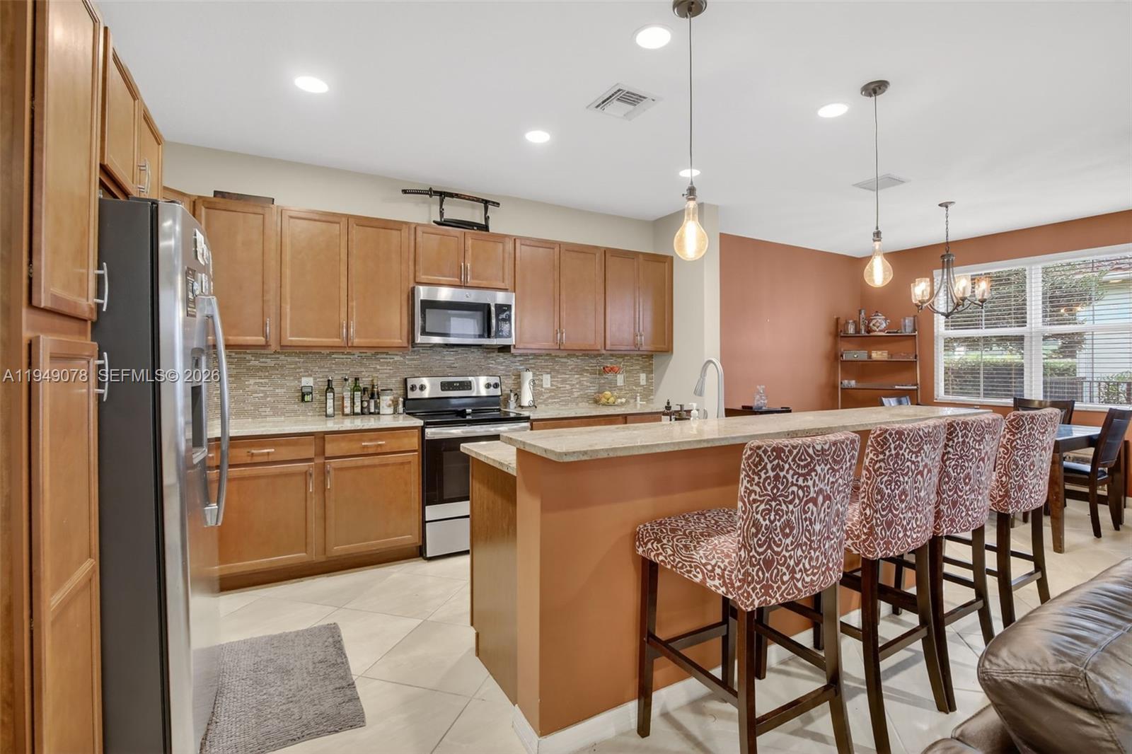 5208 Falcon Trail Davie, FL 33314 - Photo 11 of 49 a kitchen with kitchen island granite countertop wooden floors and white appliances