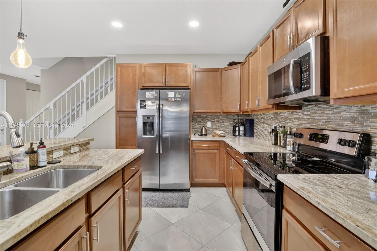5208 Falcon Trail Davie, FL 33314 - Photo 13 of 49 a kitchen with stainless steel appliances granite countertop a sink stove microwave and refrigerator