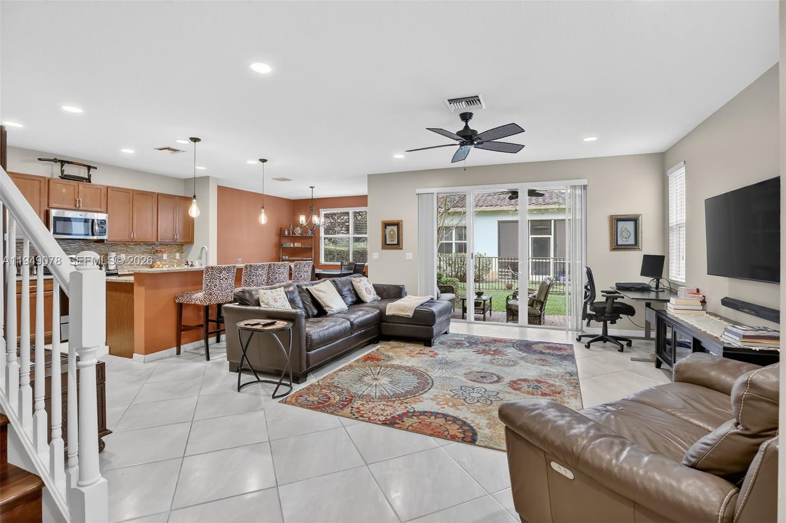 5208 Falcon Trail Davie, FL 33314 - Photo 7 of 49 a living room with furniture and a flat screen tv with kitchen view