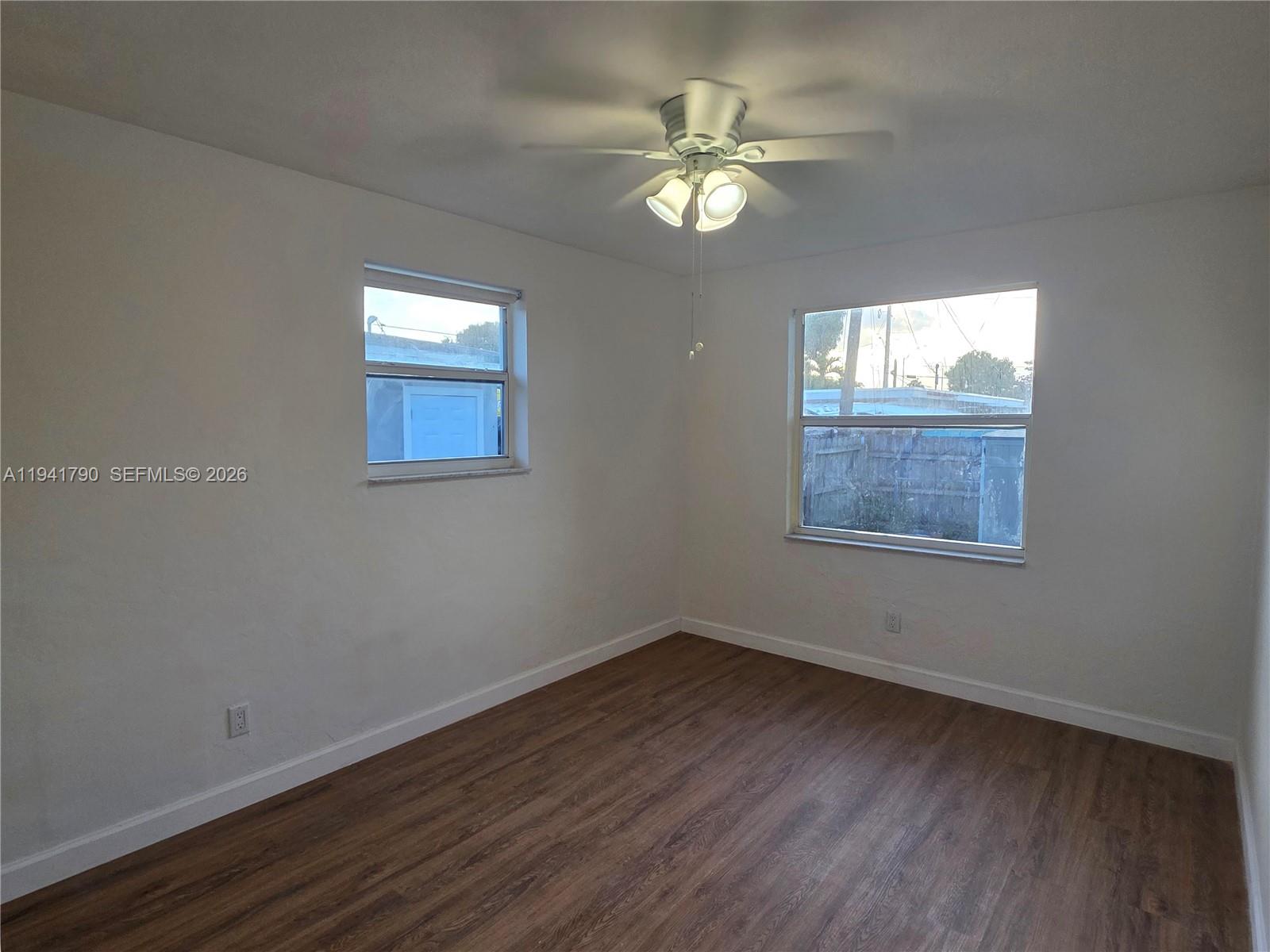 4310 East 9th Lane Hialeah, FL 33013 - Photo 15 of 21 an empty room with wooden floor and windows