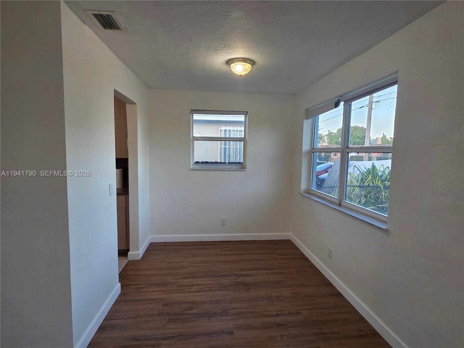 4310 East 9th Lane Hialeah, FL 33013 - Photo 6 of 21 a view of an empty room with wooden floor and a window