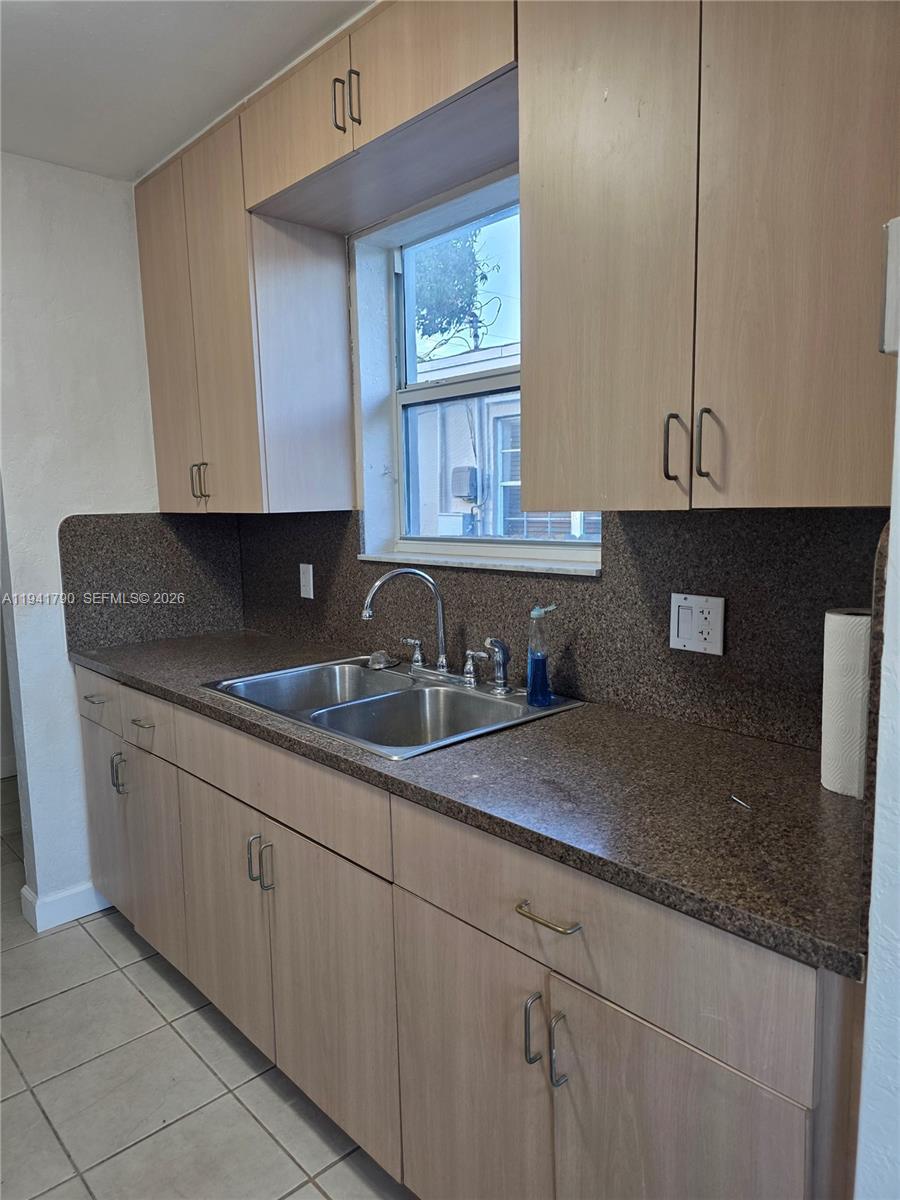 4310 East 9th Lane Hialeah, FL 33013 - Photo 7 of 21 a kitchen with granite countertop a sink a stove and cabinets