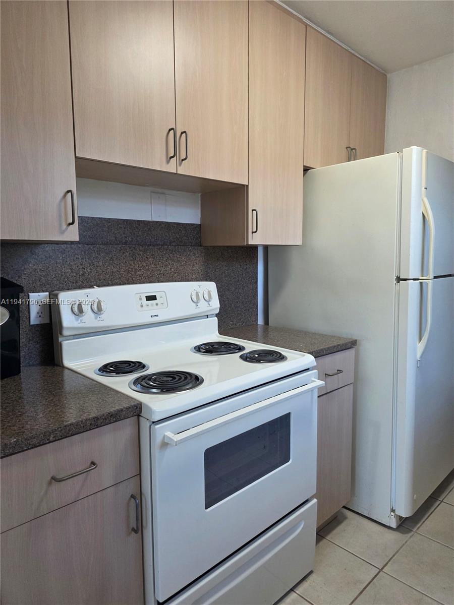 4310 East 9th Lane Hialeah, FL 33013 - Photo 8 of 21 a kitchen with a stove and a refrigerator