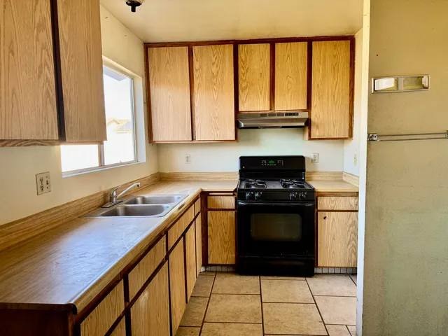 a kitchen with a sink a stove and cabinets