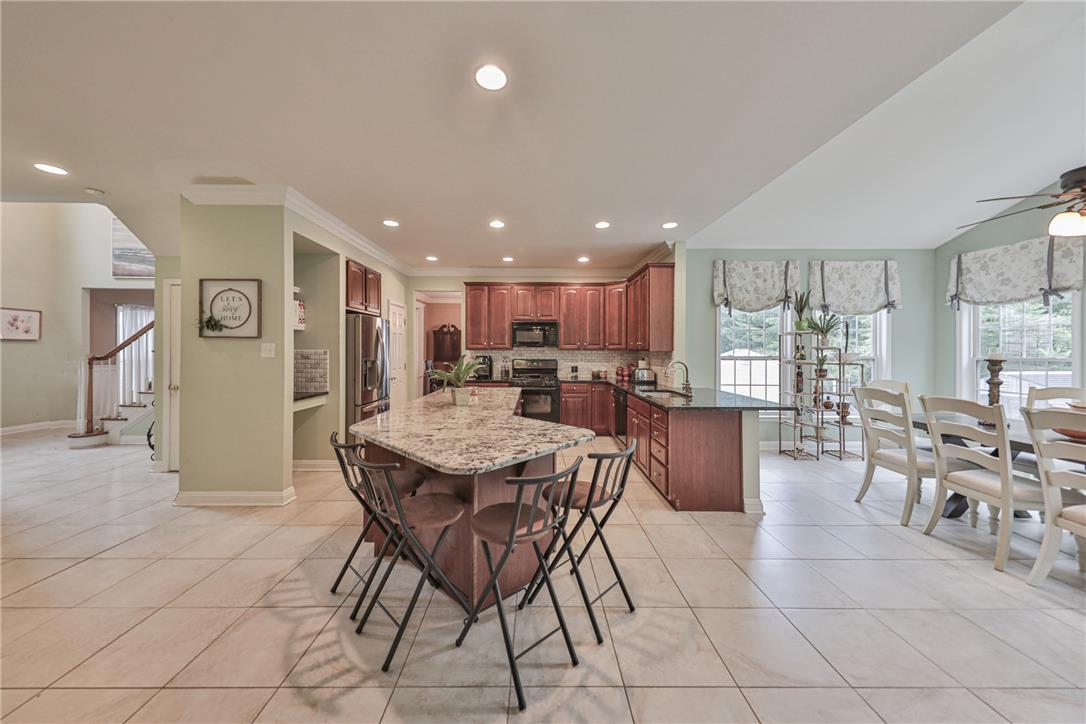 138 Clover Hollow Road Easton, PA 18045 - Photo 22 of 95 An inviting open-concept kitchen and dining area features abundant cabinetry, a spacious island, and tile flooring.
