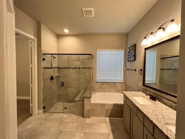 a bathroom with a granite countertop sink mirror and shower