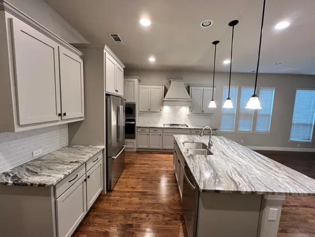 a kitchen with a stove a refrigerator and wooden cabinets