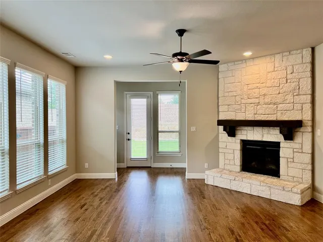 a view of empty room with wooden floor and fireplace