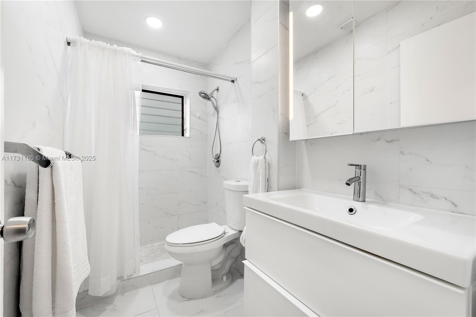 160 Northeast 8th Avenue, Unit 9B Hallandale Beach, FL 33009 - Photo 11 of 25 a bathroom with a sink a toilet and shower