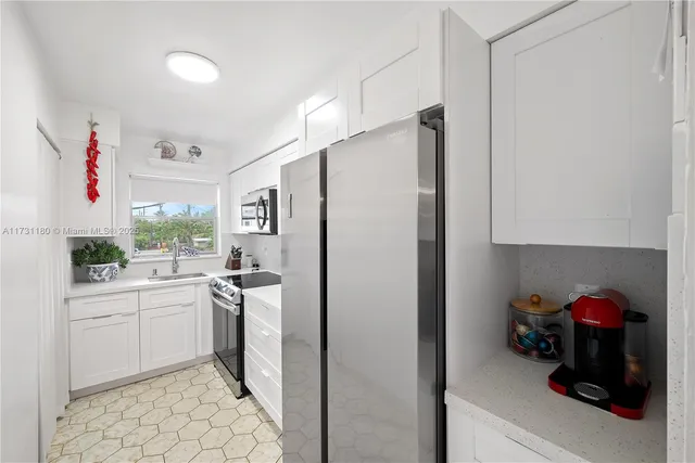 a kitchen with white cabinets and white appliances