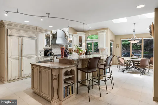 a kitchen with stainless steel appliances granite countertop a stove top oven a sink dishwasher and a dining table with kitchen view