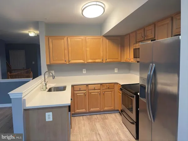 a kitchen with stainless steel appliances granite countertop a sink a refrigerator and a stove