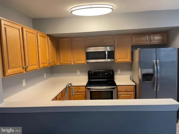 a kitchen with a refrigerator and a stove top oven