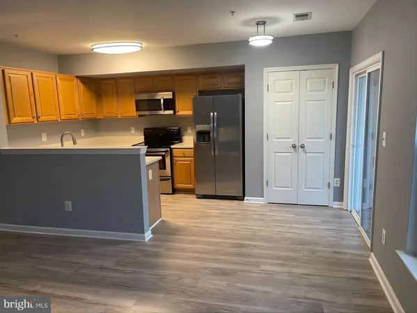 a view of a kitchen with a refrigerator cabinets and a wooden floor