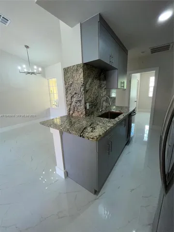 a kitchen with stainless steel appliances granite countertop a sink stove microwave and refrigerator