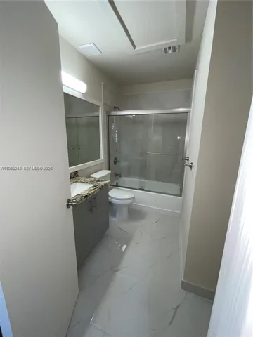 a bathroom with a sink and mirror with toilet
