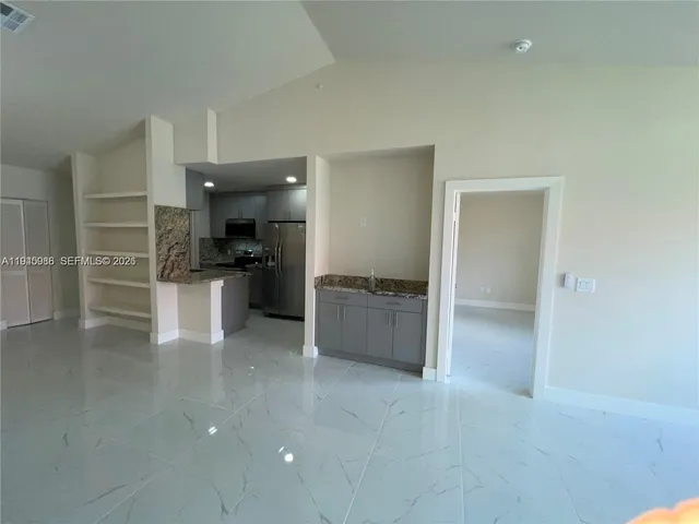 a large kitchen with stainless steel appliances a refrigerator and a stove top oven