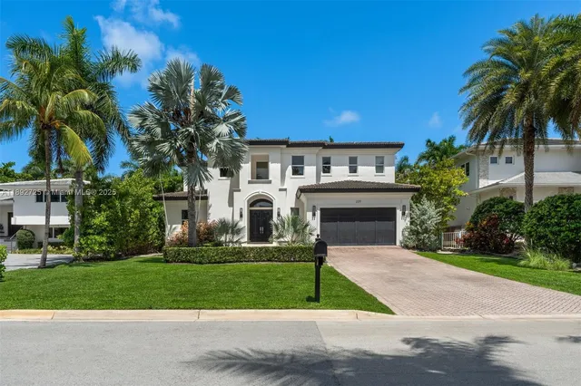 a front view of a house with a garden and palm tree