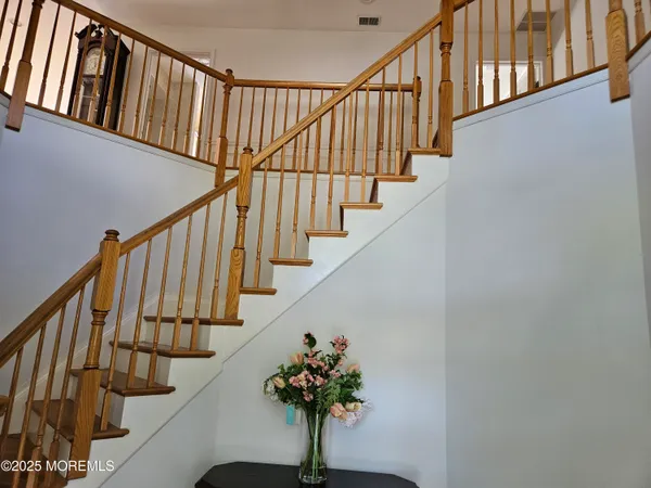 a kitchen with a stove a refrigerator and a dining table with wooden floor