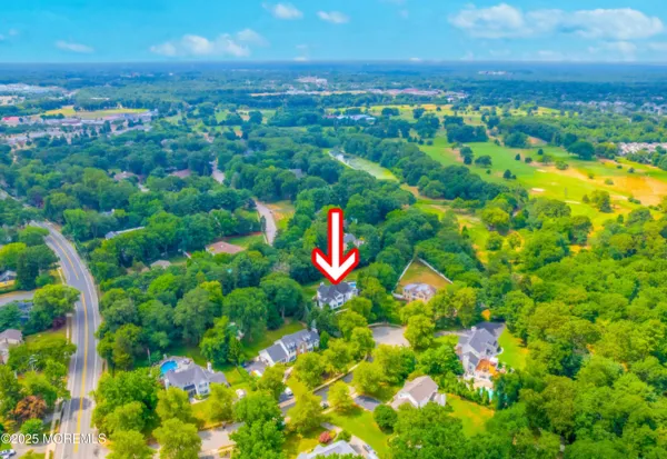 an aerial view of a house with a yard and lake view