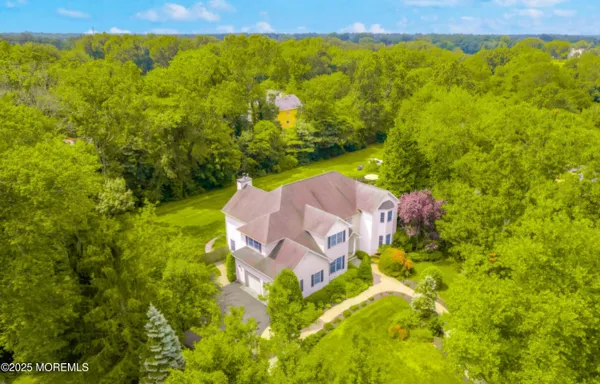 an aerial view of a house with a yard and lake view