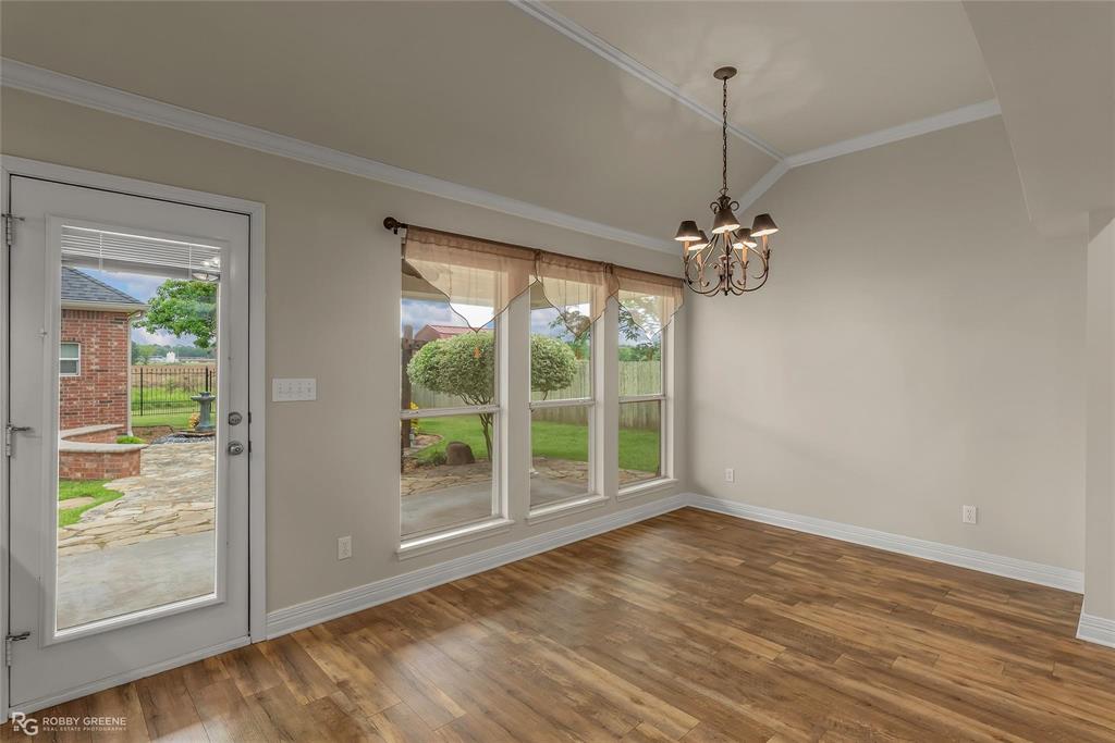 2186 Stockwell Road Bossier City, LA 71111 - Photo 14 of 40 Unfurnished dining area with ornamental molding, vaulted ceiling, healthy amount of natural light, dark wood-style flooring, and hanging lights