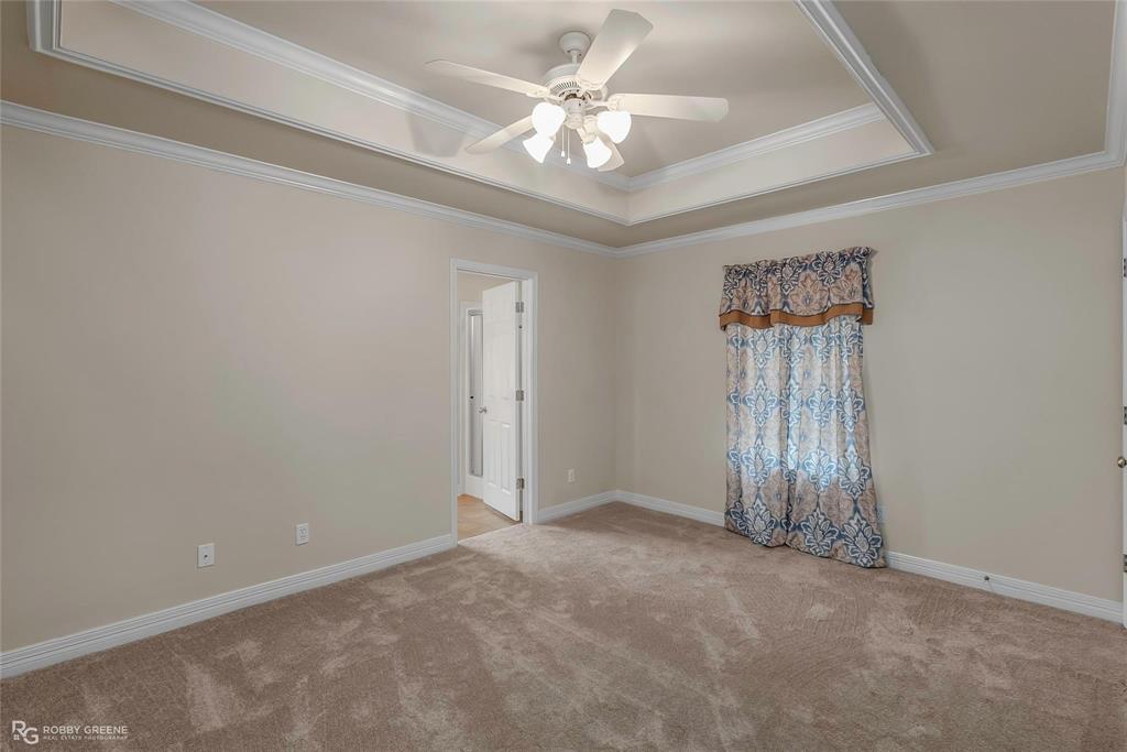 2186 Stockwell Road Bossier City, LA 71111 - Photo 15 of 40 Empty room featuring ceiling fan, light carpet, a tray ceiling, and crown molding