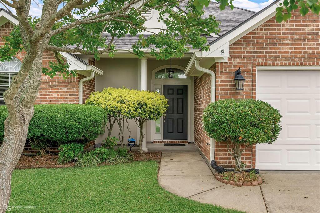 2186 Stockwell Road Bossier City, LA 71111 - Photo 2 of 40 Property entrance featuring roof with shingles, an attached garage, and brick siding