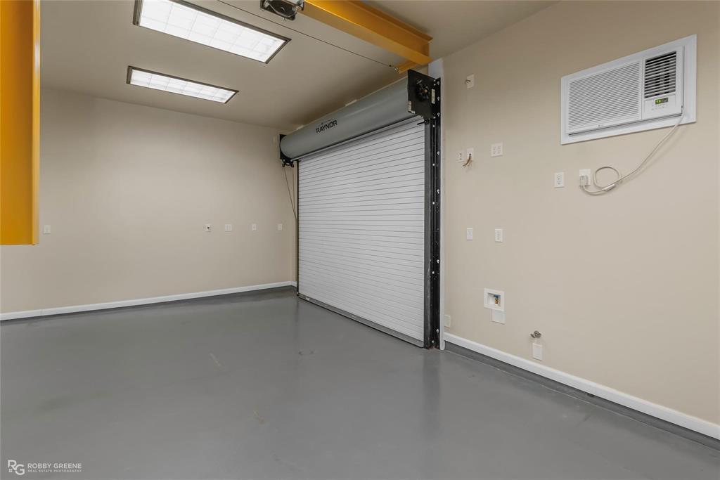 2186 Stockwell Road Bossier City, LA 71111 - Photo 25 of 40 Garage featuring baseboards and a wall mounted air conditioner