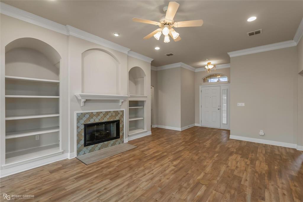 2186 Stockwell Road Bossier City, LA 71111 - Photo 7 of 40 Unfurnished living room with built in features, a ceiling fan, dark wood finished floors, crown molding, and recessed lighting