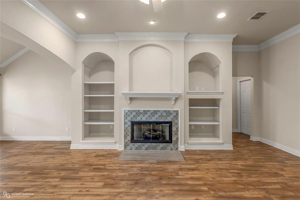 2186 Stockwell Road Bossier City, LA 71111 - Photo 8 of 40 Unfurnished living room featuring built in features, crown molding, wood finished floors, a fireplace, and recessed lighting