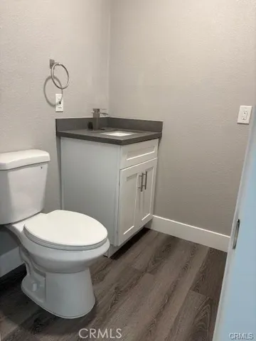 a kitchen with a refrigerator a stove top oven a sink dishwasher and white cabinets with wooden floor