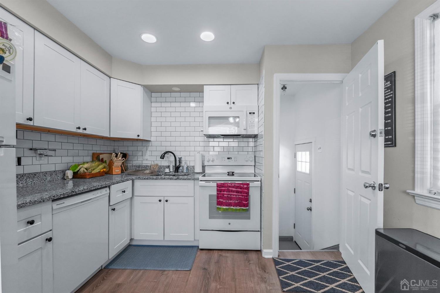 1067 Riverton Street North Brunswick, NJ 08902 - Photo 11 of 45 a kitchen with stainless steel appliances a sink cabinets and wooden floor