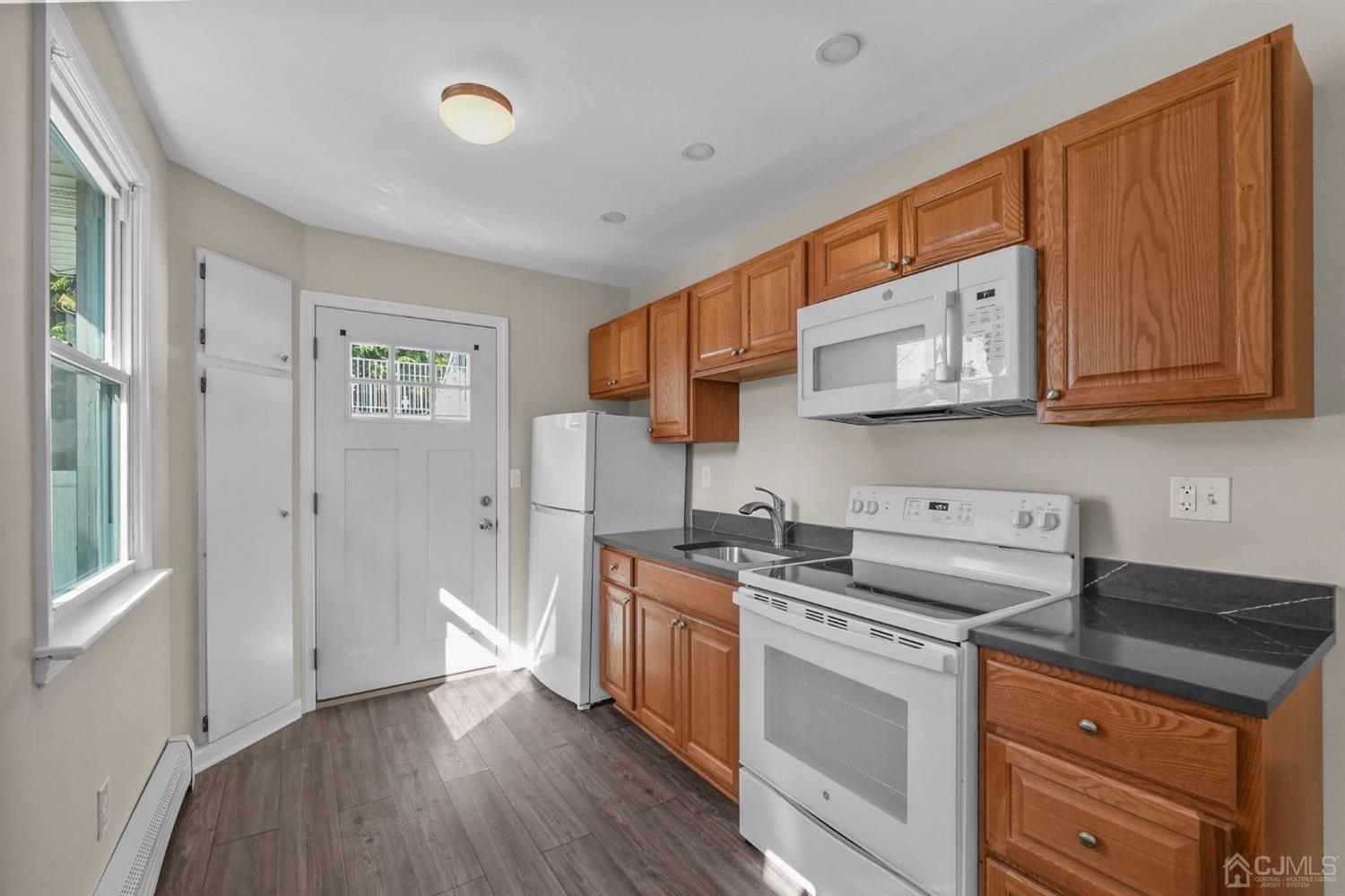 1067 Riverton Street North Brunswick, NJ 08902 - Photo 24 of 45 a kitchen with stainless steel appliances granite countertop a sink and cabinets with wooden floor