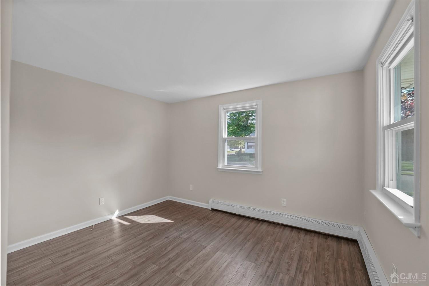 1067 Riverton Street North Brunswick, NJ 08902 - Photo 26 of 45 an empty room with wooden floor and windows