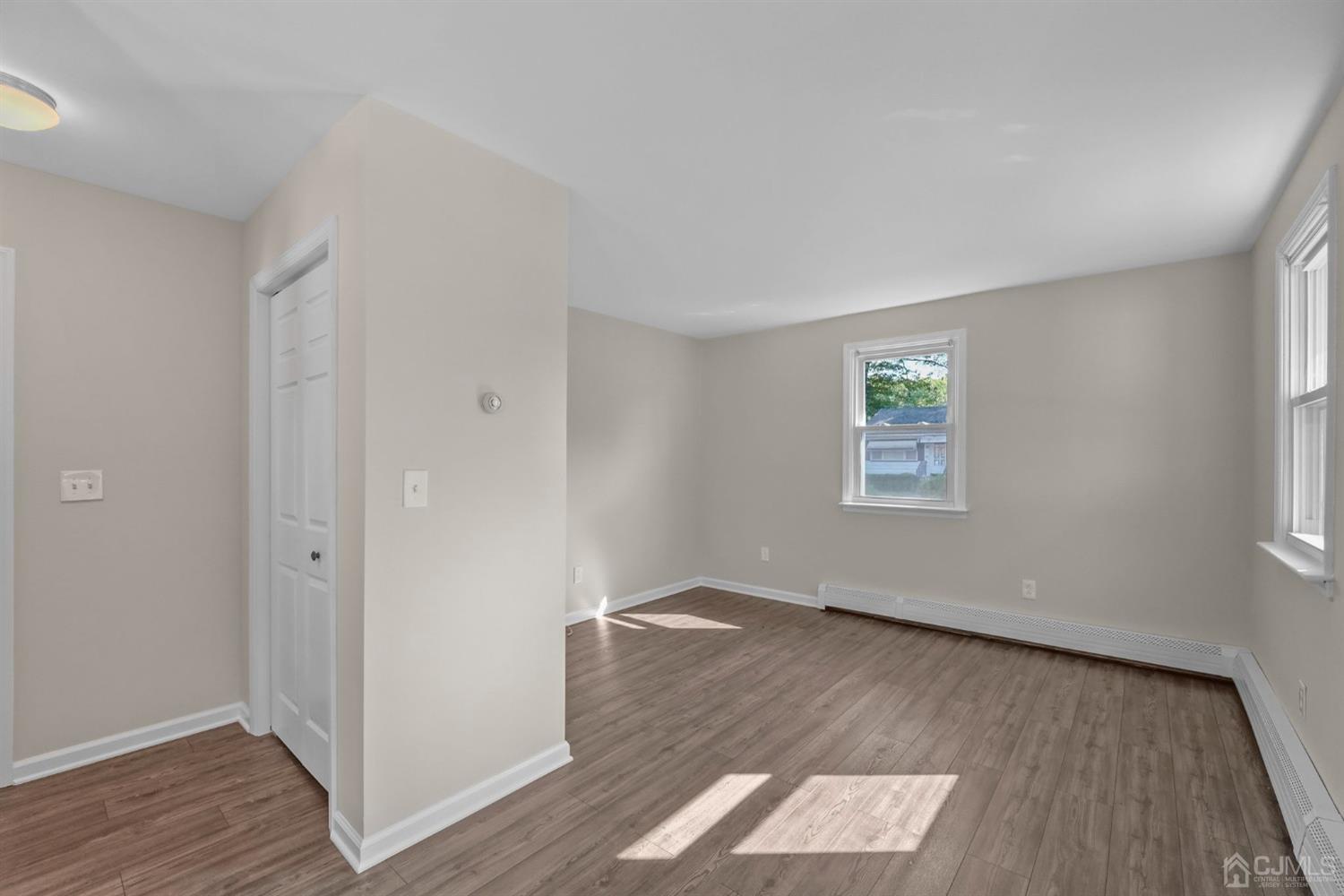 1067 Riverton Street North Brunswick, NJ 08902 - Photo 30 of 45 an empty room with wooden floor and windows