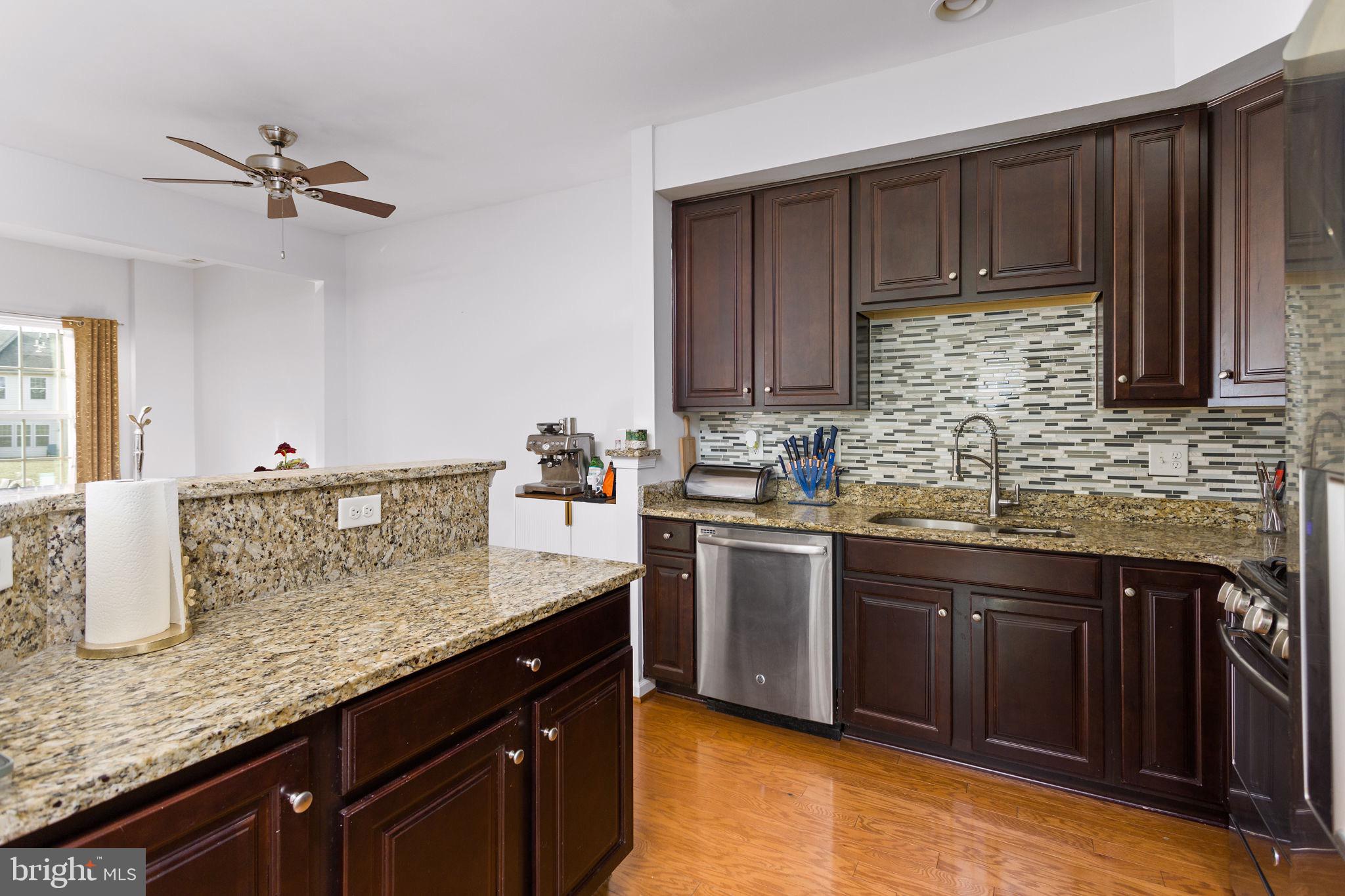 21 Sundance Drive Hamilton, NJ 08619 - Photo 12 of 29 a kitchen with stainless steel appliances granite countertop a sink dishwasher stove and refrigerator with wooden floor