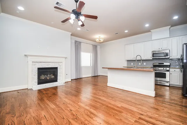 a view of kitchen with granite countertop stainless steel appliances and wooden floor