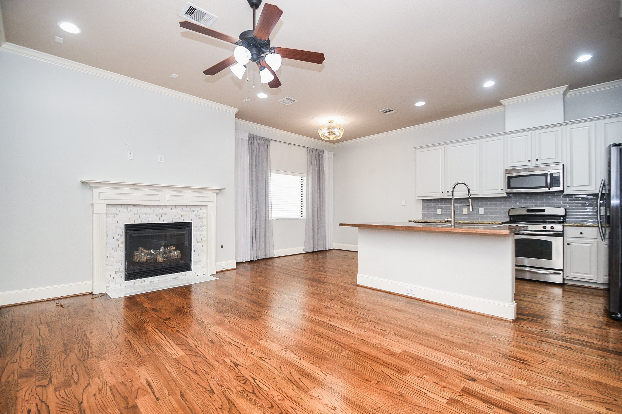 1222 West 17th Street, Unit D Houston, TX 77008 - Photo 1 of 35 a view of kitchen with granite countertop stainless steel appliances and wooden floor
