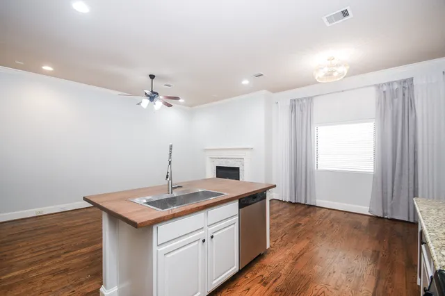 a kitchen with a sink chandelier and wooden floor