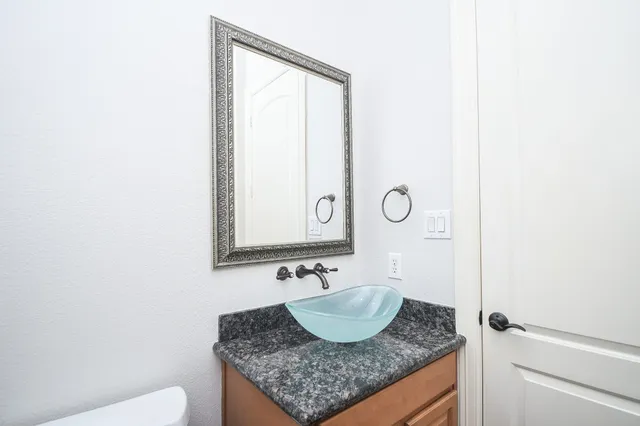 a bathroom with a granite countertop sink and a mirror