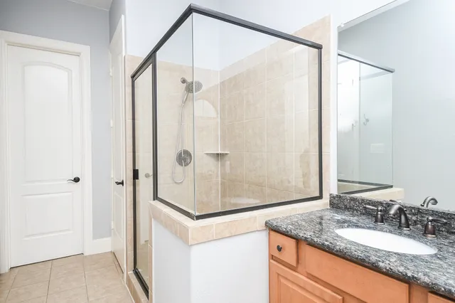 a bathroom with a granite countertop sink mirror and shower