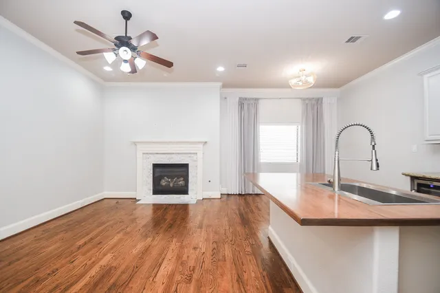 a view of a livingroom with a fireplace a chandelier and wooden floor