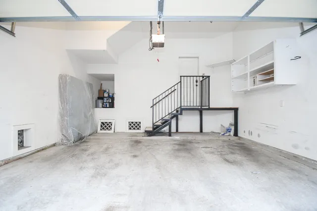a view of empty room with stairs and white walls